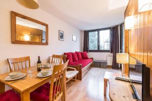 a living room with a table and a red couch at Apartment Chamois Blanc 2B in Chamonix