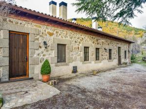 ein Steingebäude mit einer Tür und einer Anlage davor in der Unterkunft Posada Peña Pintada by Vivere Stays in Cercedilla