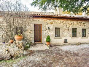 ein Steinhaus mit einer Tür und einem Hof in der Unterkunft Posada Peña Pintada by Vivere Stays in Cercedilla