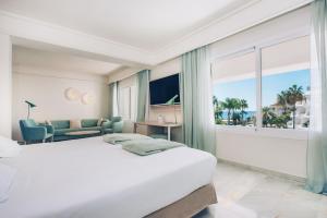 a hotel room with a bed and a large window at Iberostar Selection Marbella Coral Beach in Marbella