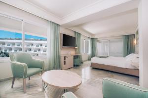 a hotel room with a bed and a table and chairs at Iberostar Selection Marbella Coral Beach in Marbella