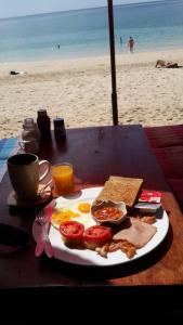 um prato de comida de pequeno-almoço numa mesa na praia em chill chill long beach hostel em Ko Lanta