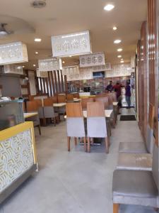 a restaurant with wooden tables and chairs and people at Sapphire stay in Bangalore
