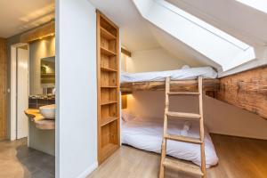 a room with bunk beds and a ladder at Apartment Genevrier - Spacious Balcony with Mont Blanc Views in Chamonix-Mont-Blanc