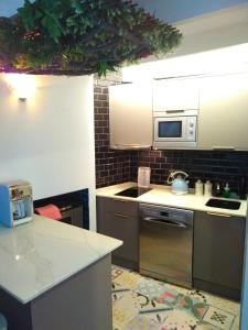 a kitchen with a stove and a microwave at Quacketta in Villajoyosa