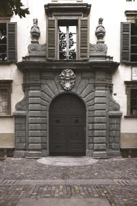 un edificio con una porta nera e una finestra di Palazzo Salis - La Dimora del Conte a Tirano