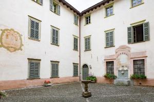 un grand bâtiment blanc avec des fenêtres et une fontaine dans l'établissement Palazzo Salis - La Dimora del Conte, à Tirano
