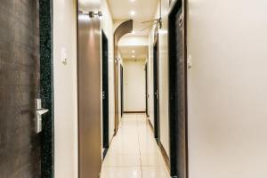 einen Flur in einem Hotel mit weißen Wänden und Fliesenboden in der Unterkunft FabExpress Adore Inn - Nr Mumbai International Airport in Mumbai + 22 Fotos