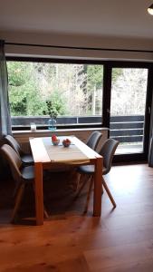 a table and chairs in a room with a large window at Ferienwohnung direkt am Skigebiet und Bikepark in Winterberg +2 photos