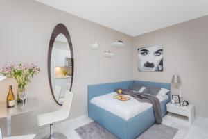 a bedroom with a blue bed and a mirror at VISIONAPARTMENTS Rotachstrasse - contactless check-in in Zürich