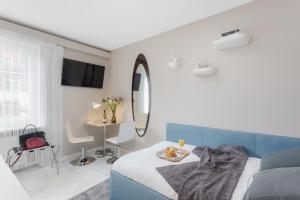 um quarto branco e azul com uma cama e um espelho em VISIONAPARTMENTS Rotachstrasse - contactless check-in em Zurique