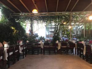 ein Esszimmer mit Tischen, Stühlen und Pflanzen in der Unterkunft Hotel Uygar in Fethiye