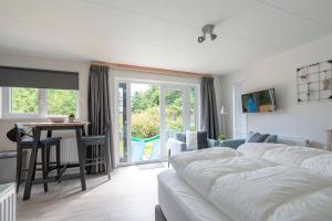 a bedroom with a bed and a table and a dining room at Chalet studio Mees - Texel in De Koog