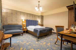 Hotel Diament Plaza Gliwice في جليفيتش: غرفة فندقية بسرير وطاولة وكراسي