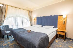 グリヴィツェにあるホテル ディアメント プラザ グリヴィツェの大きなベッドと椅子が備わるホテルルームです。