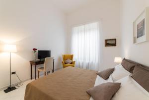 a bedroom with a bed and a desk with a computer at Ecce Homo 28 in Naples