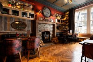 a restaurant with a fireplace and a table and chairs at The Ambleside Inn - The Inn Collection Group in Ambleside