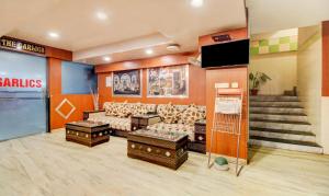 a waiting room with couches and a tv and stairs at Hotel Amanda in Lucknow