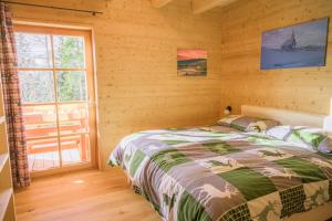 ein Schlafzimmer mit einem Bett in einem Blockhaus in der Unterkunft Apartment Fuchsbau in Lachtal