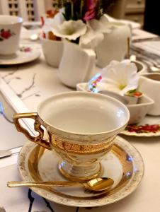 a gold tea cup on a plate on a table at Carmel Villa B&B or Self-Catering in Calvinia