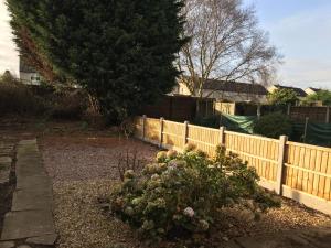 a fence in a yard with a flower garden at Webb Lodge in Telford