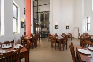 a dining room with wooden tables and chairs at Golden Pier City Hotel in Colombo