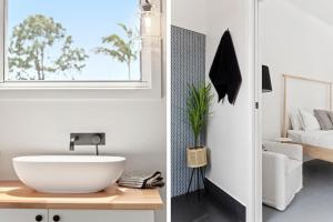 a bathroom with a white sink and a bedroom at Studio Ocean Breeze @ Huskisson in Huskisson