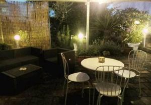 un patio con tavolo e sedie di notte di BB La casa di Tella a Carosino