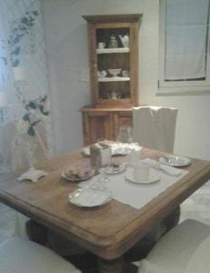 un tavolo di legno con piatti e bicchieri di BB La casa di Tella a Carosino