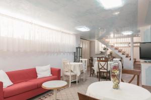 salon z czerwoną kanapą i stołem w obiekcie Hotel Altair w mieście Misano Adriatico