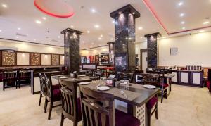 restauracja ze stołami i krzesłami oraz bar w obiekcie Treebo Trend Pawan Putra w mieście Kolkata