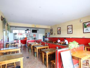 un restaurant avec des tables en bois et des banquettes rouges dans l'établissement 7Days Inn Beijing Yizhuang Development Zone, à Pékin