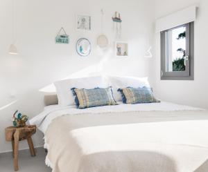 a white bedroom with a large white bed with pillows at Mariya Art Living in Nea Skioni
