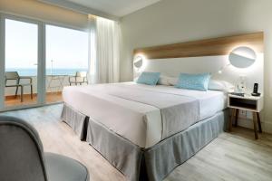 1 dormitorio con 1 cama grande y vistas al océano en Hotel Benalma Costa del Sol, en Benalmádena