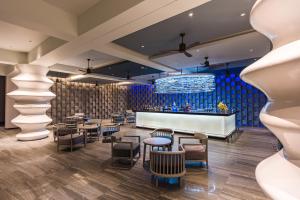 a restaurant with tables and chairs and a bar at Oceanfront Beach Resort - SHA Extra Plus in Patong Beach