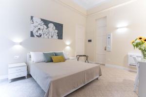 um quarto branco com uma cama e um quadro na parede em Donna Isa B&B em Palermo