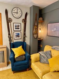 a living room with a couch and a clock on the wall at Anayet Sweet Home in Formigal