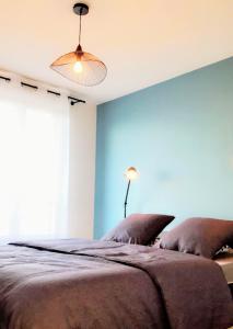 a bedroom with a large bed with a blue wall at #Design & Indus Sweet Loft ! in Saint-Dizier