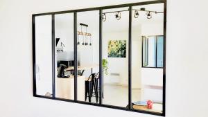 a large mirror with black frame on a white wall at #Design & Indus Sweet Loft ! in Saint-Dizier