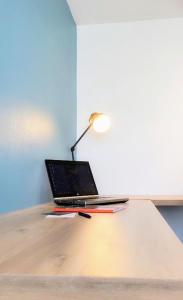 a laptop computer sitting on a desk with a lamp at #Design & Indus Sweet Loft ! in Saint-Dizier