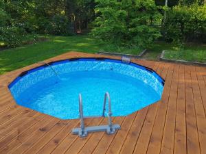 a swimming pool on a deck with a wooden deck at Kosiedlisko in Kraśnik