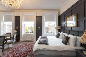 a bedroom with a large bed and a chandelier at The Warren Belfast in Belfast
