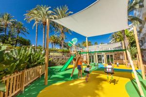 una familia jugando en un parque infantil en un complejo en Abora Catarina by Lopesan Hotels en Playa del Ingles