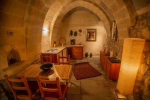 a kitchen with a table and a stove in a room at Asmalı Cave House in Uchisar