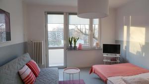 a living room with a couch and a television at Lovely Madly Apartment in Krakow