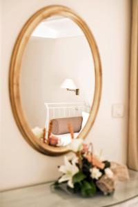 a mirror on top of a table with flowers at Hotel Azimut in Sveti Stefan