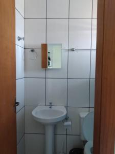 因貝的住宿－Pousada Recanto da Barra Imbé，白色的浴室设有水槽和卫生间。