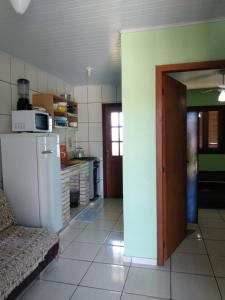 een keuken met een koelkast en een bank in een kamer bij Pousada Recanto da Barra Imbé in Imbé