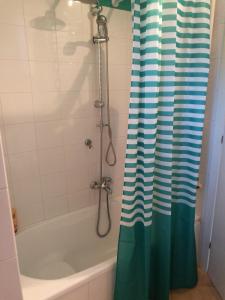 a bathroom with a shower with a green and white shower curtain at cherryhome in Arizzano