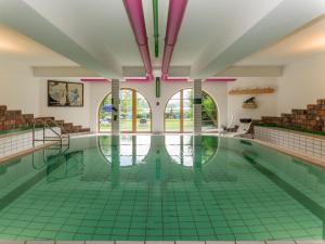 an indoor swimming pool with a green tile floor at Appartement-Hotel Seespitz in Füssen